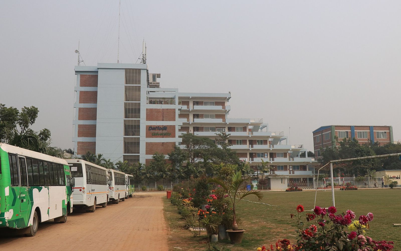 FGD Preparation for MNC Jobs in Bangladesh: What Employers and Recruits Have Put on Record 1 The CV Guy is the No.1 Resume/CV Writer in Bangladesh, Asia & Middle East A white and brick academic building of Daffodil International University in Dhaka, with parked university buses on the left and a football field on the right
