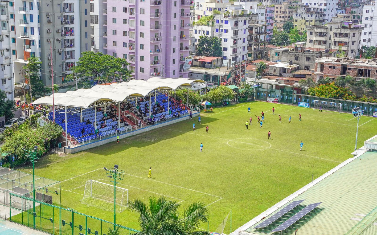 What a Fresher CV for an MNC Application Should Contain: The Record in Bangladesh 1 The CV Guy is the No.1 Resume/CV Writer in Bangladesh, Asia & Middle East A football match on a university ground in Dhaka seen from above, with students watching from a covered stand and apartment blocks behind